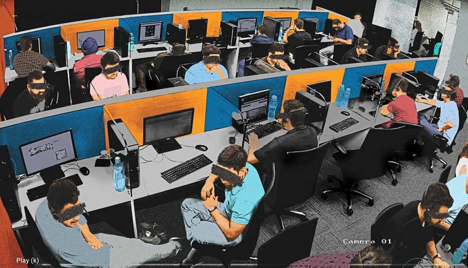 security camera still from a fraud factory office showing people working at cubicles with their faces obscured to hide their identity