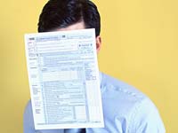 Man With 1040 tax form covering face, Tax Resources in Spanish