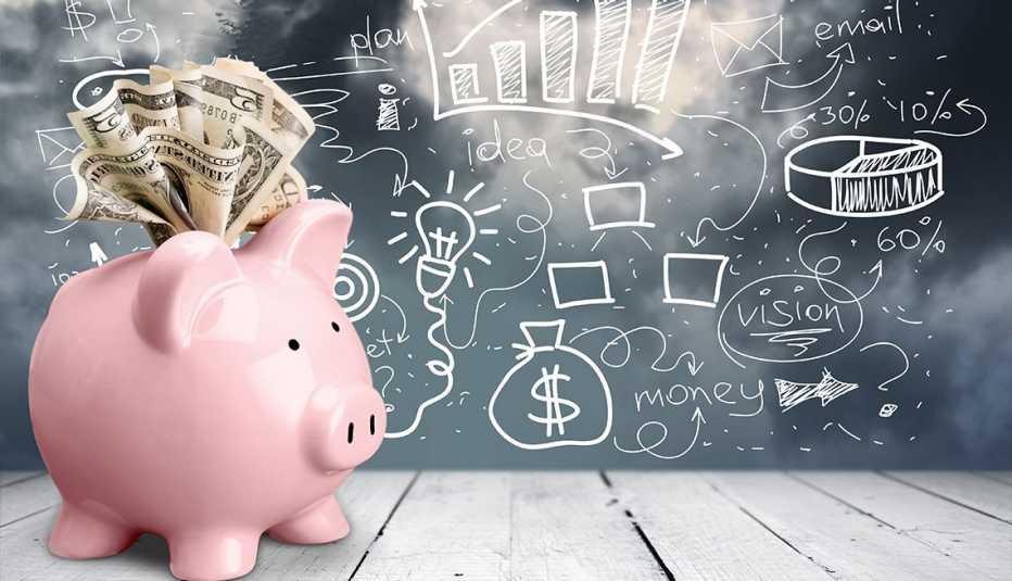 pink piggy bank stuffed with dollars in front of a chalk board full of ideas like retirement wants and needs