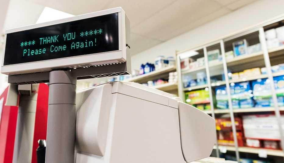 Check out counter at a pharmacy with an illuminated register display that reads, "Thank you. Please come again."