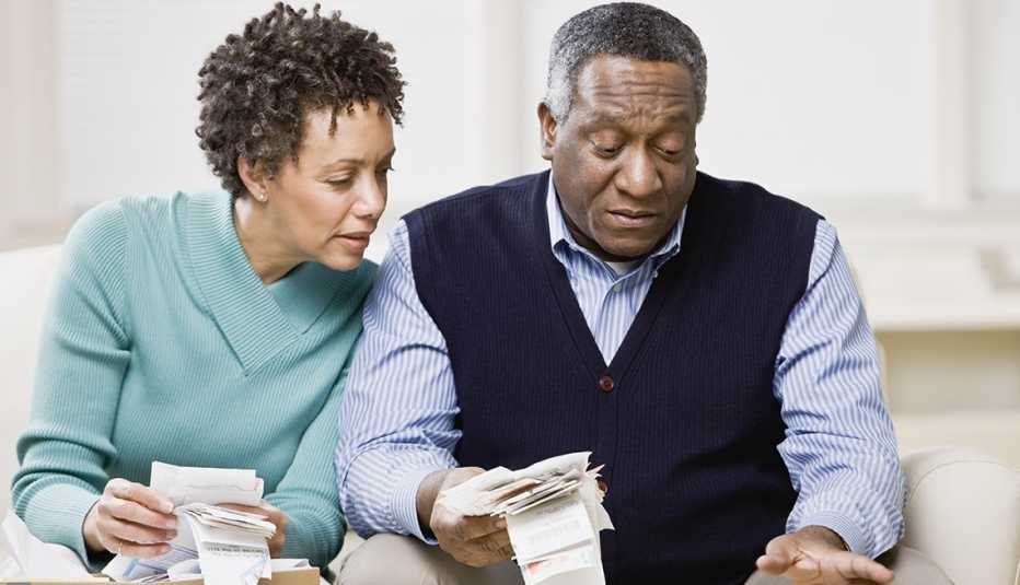 seated couple looking through handfuls of organized and potentially deductible tax receipts