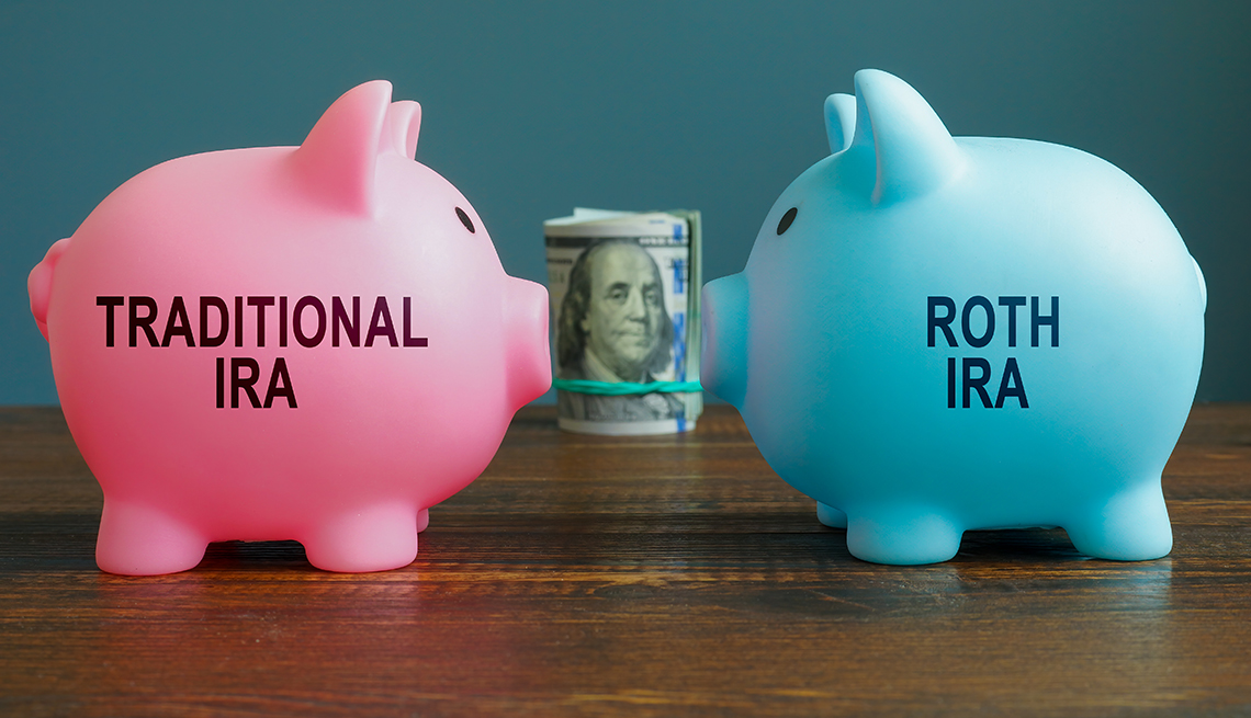 Two piggy banks, labeled Traditional IRA and Roth IRA, stand face-to-face with a roll of money between them. 