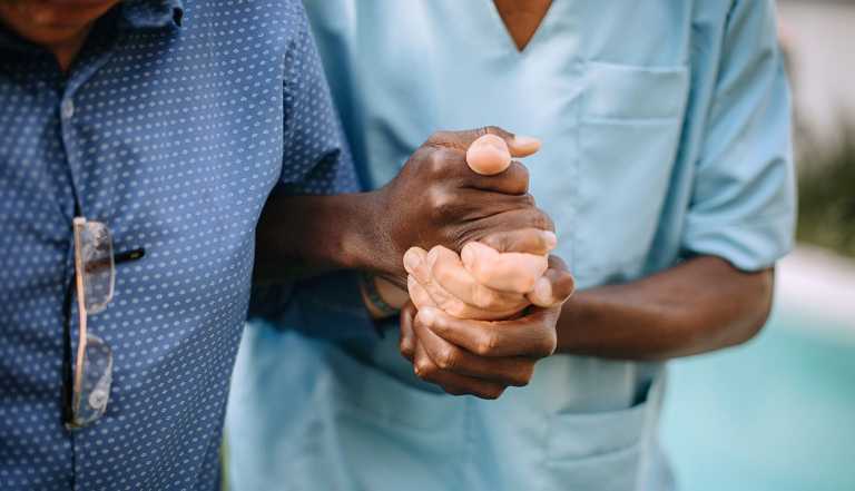 a nurse is holding a patients hand