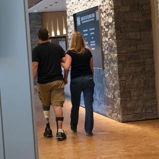 A wounded warrior and friend walk into the kitchen area. Veterans Day 2013. (Cherie Cullen/USO)