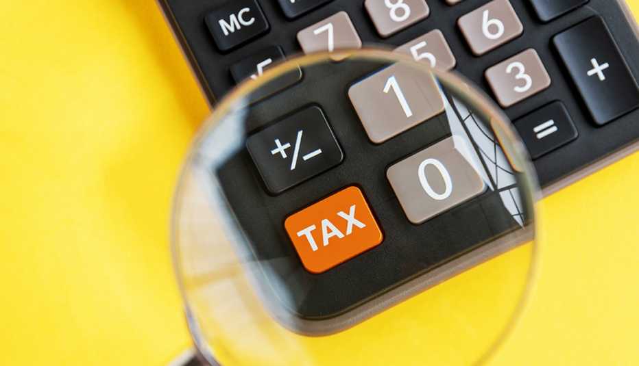 Calculator with orange "tax" button under magnifying glass