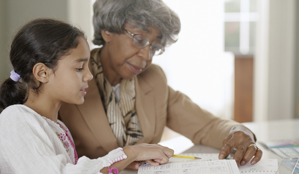 Grandmother helps her granddaughter with homework