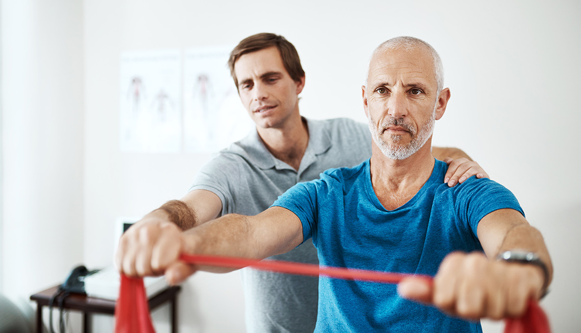 physical therapist helping older man stretch