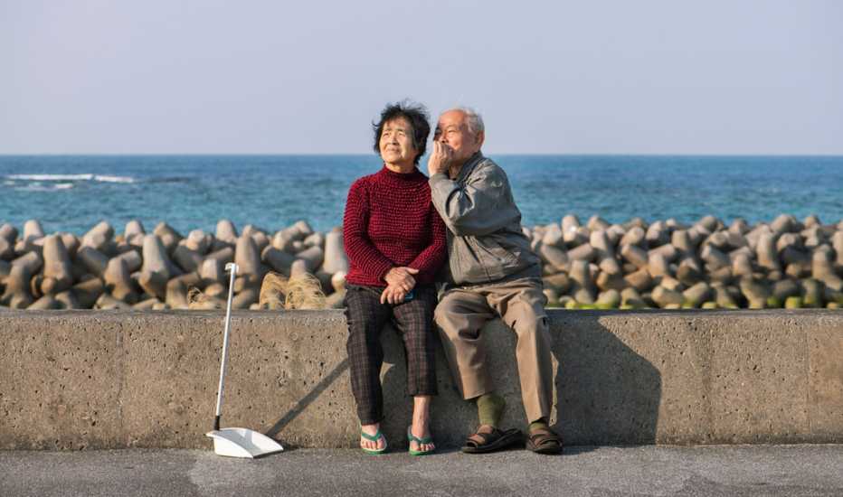 Couple in their 90s sitting on a sea wall