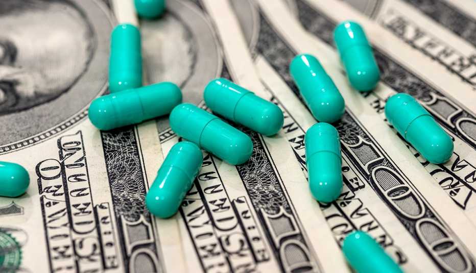 Green colored pills on a stack of money