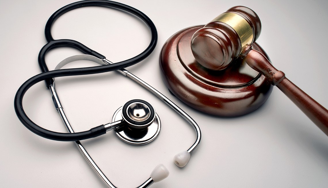 a brown wooden gavel next to a stethoscope