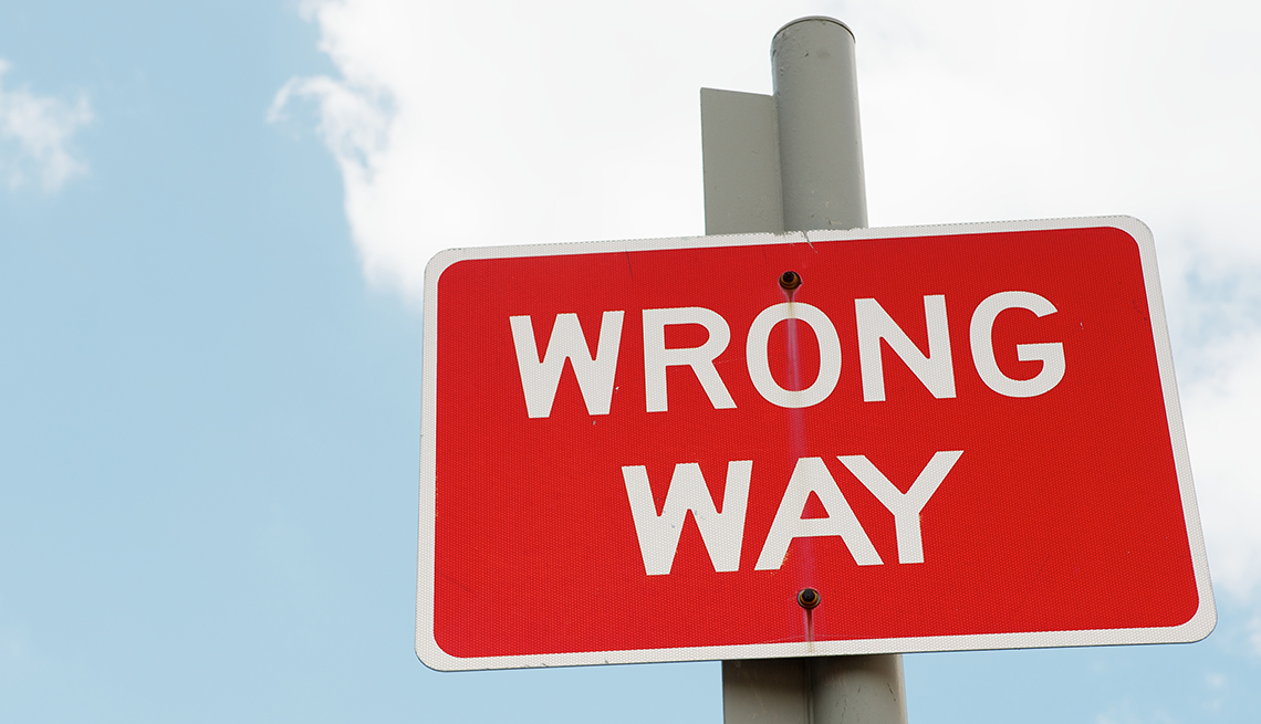 a red street sign that says wrong way