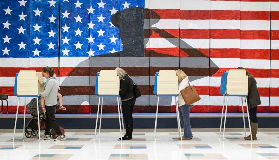 People vote in front of an American flag