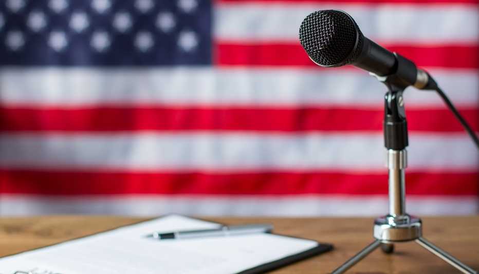 American flag, microphone and paper. Clipboard and microphone beside it on table