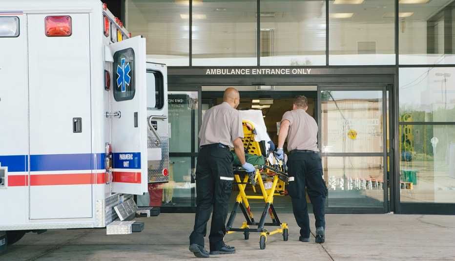 patient on gurney being wheeled into hospital emergency room
