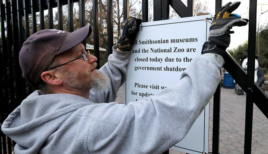 Man takes down a sign at the National Zoo