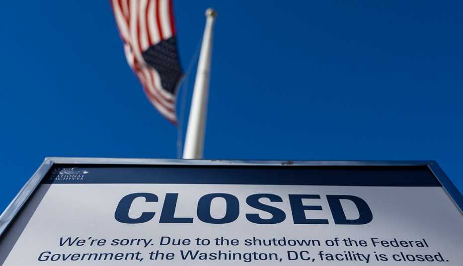 A sign that says closed with the American flag flying above it