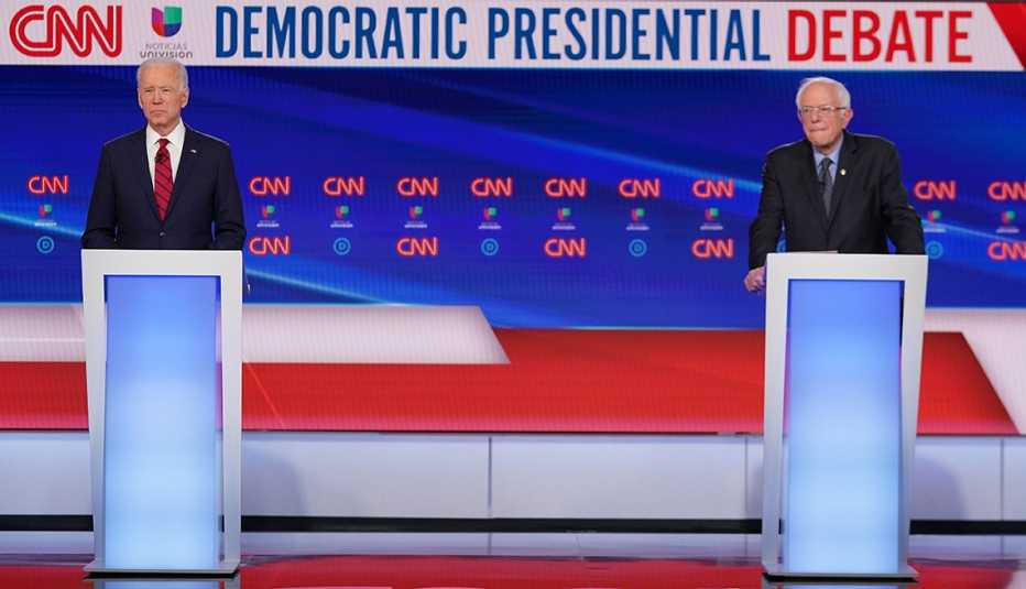 Joe Biden and Bernie Sanders stand on stage before the debate