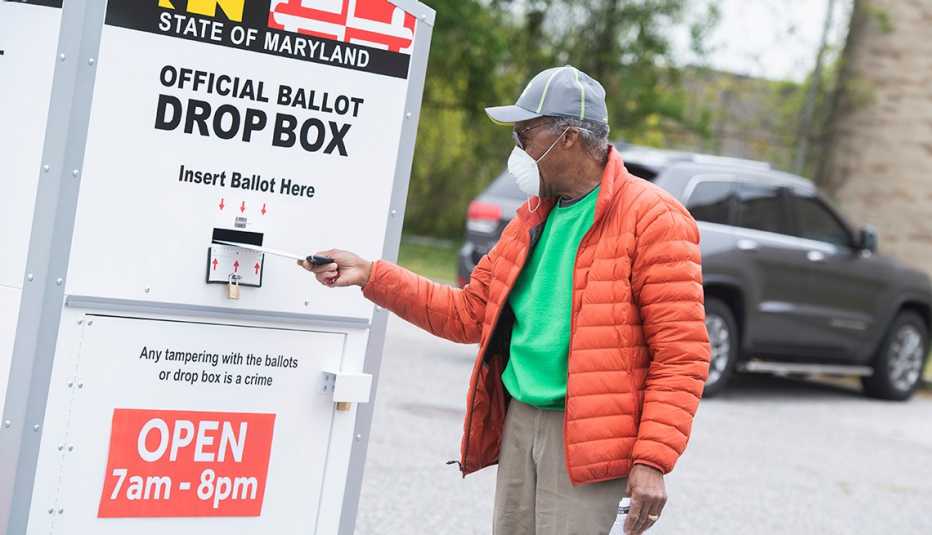 A person turns in his ballot at a drop box