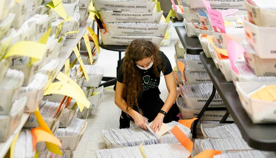 A woman sorts through hundreds of ballots