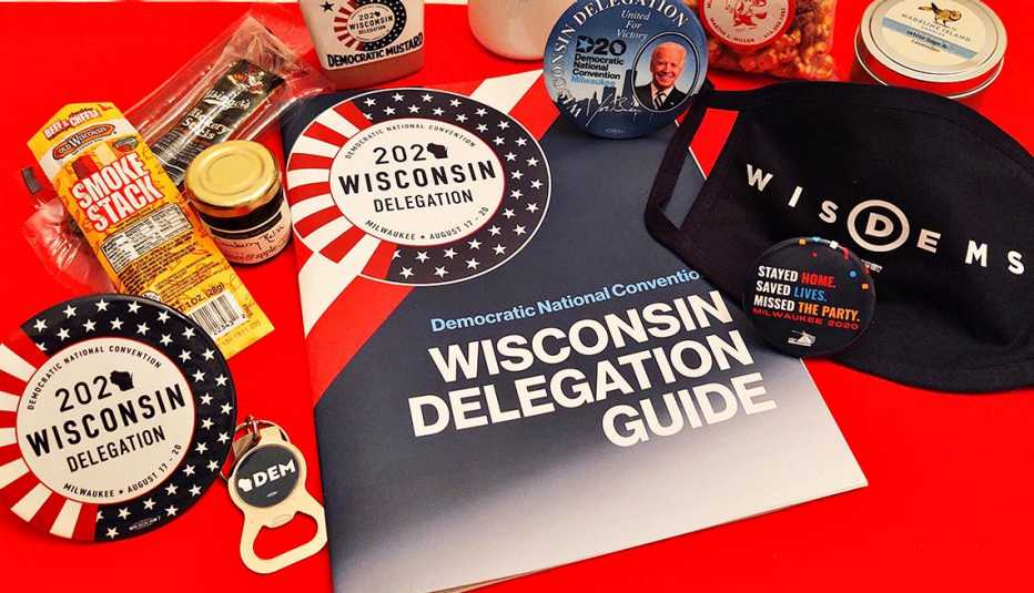 delegate swag from the twenty twenty democratic national convention in wisconsin features a face mask buttons bottle opener stickers and cheese