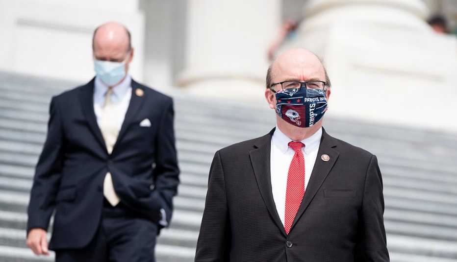 Two men walking up steps wearing masks