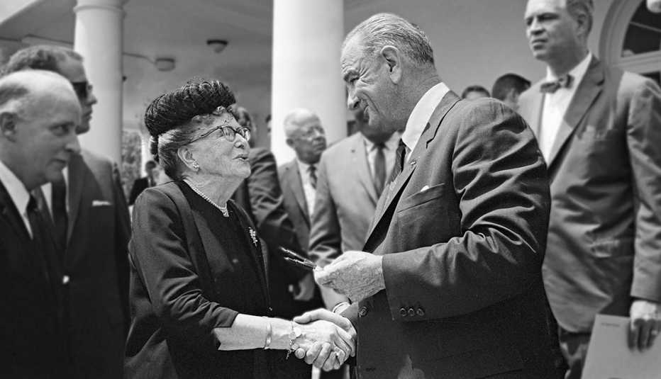 President Lyndon Johnson offers Dr. Ethel Percy Andrus a pen he used to sign the Older Americans Act.