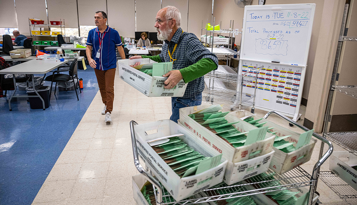 a man carries ballots to be counted