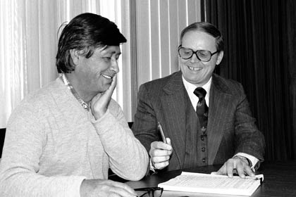 In 1978, Labor Secretary Ray Marshall, right, hands a pen to César Chávez, president of the United Farm Workers union, during a ceremony at which the DOL signed a $500,000 contract with Chávez to provide English language training and other services to approximately 1,500 migrant and seasonal farm workers. 