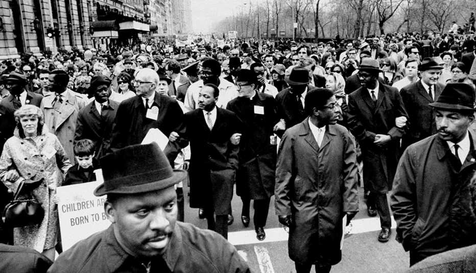 martin luther king marches, arms locked, in protest of the vietnam war