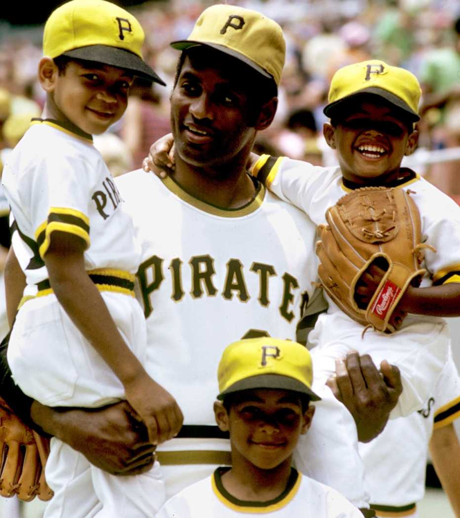 Pittsburgh Pirates Roberto Clemente stands in front of his father and brothers