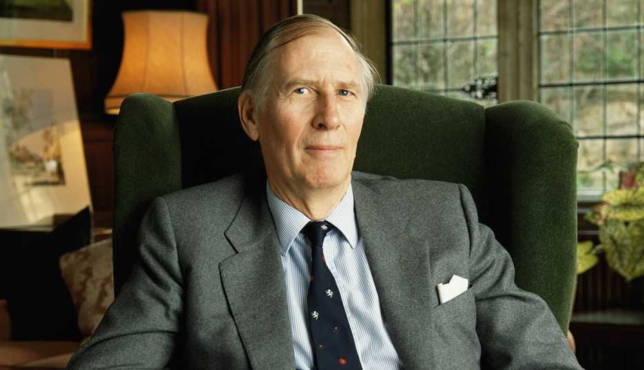 Roger Bannister sitting in upholstered chair, wearing suit