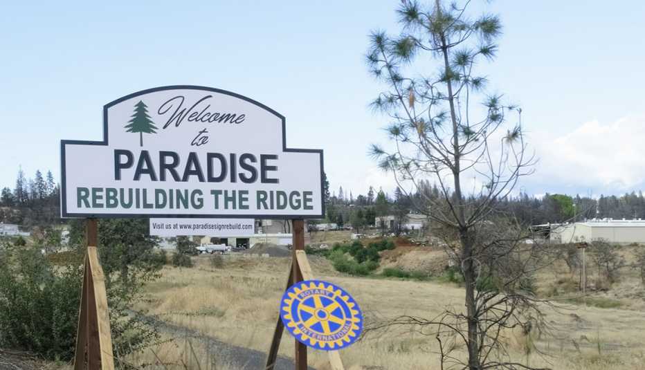 A white sign that says welcome to paradise rebuilding the ridge