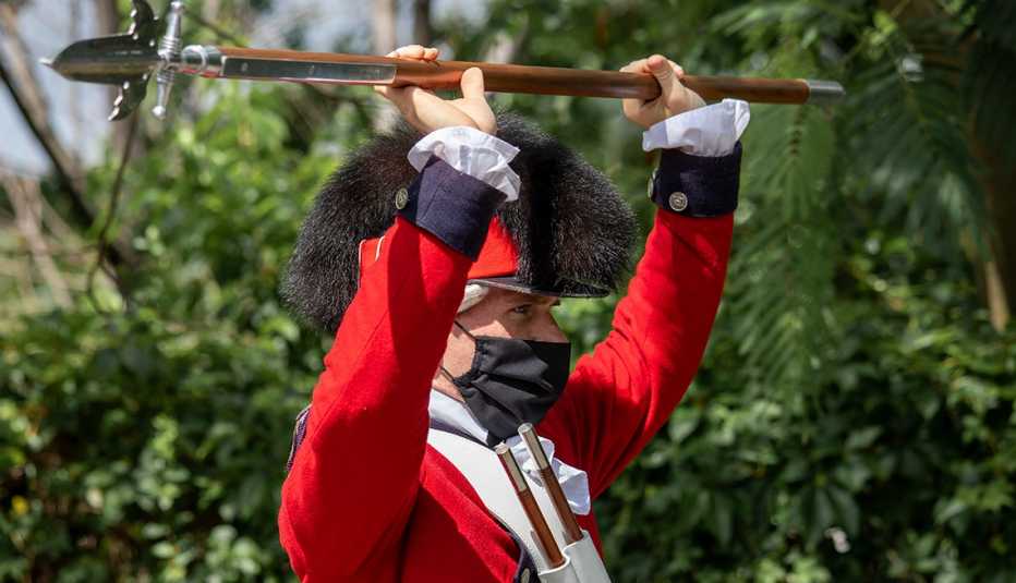 a new soldier in training for the united states army old guard fife and drum corps raises his spear over his head in an exercise