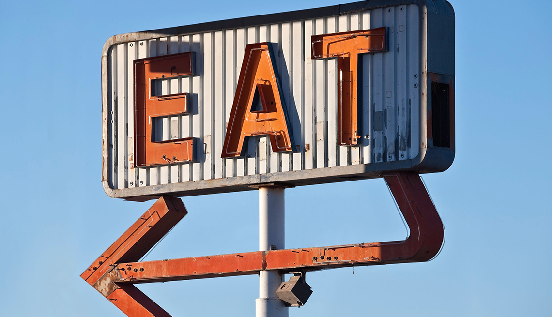antique road sign that says eat 