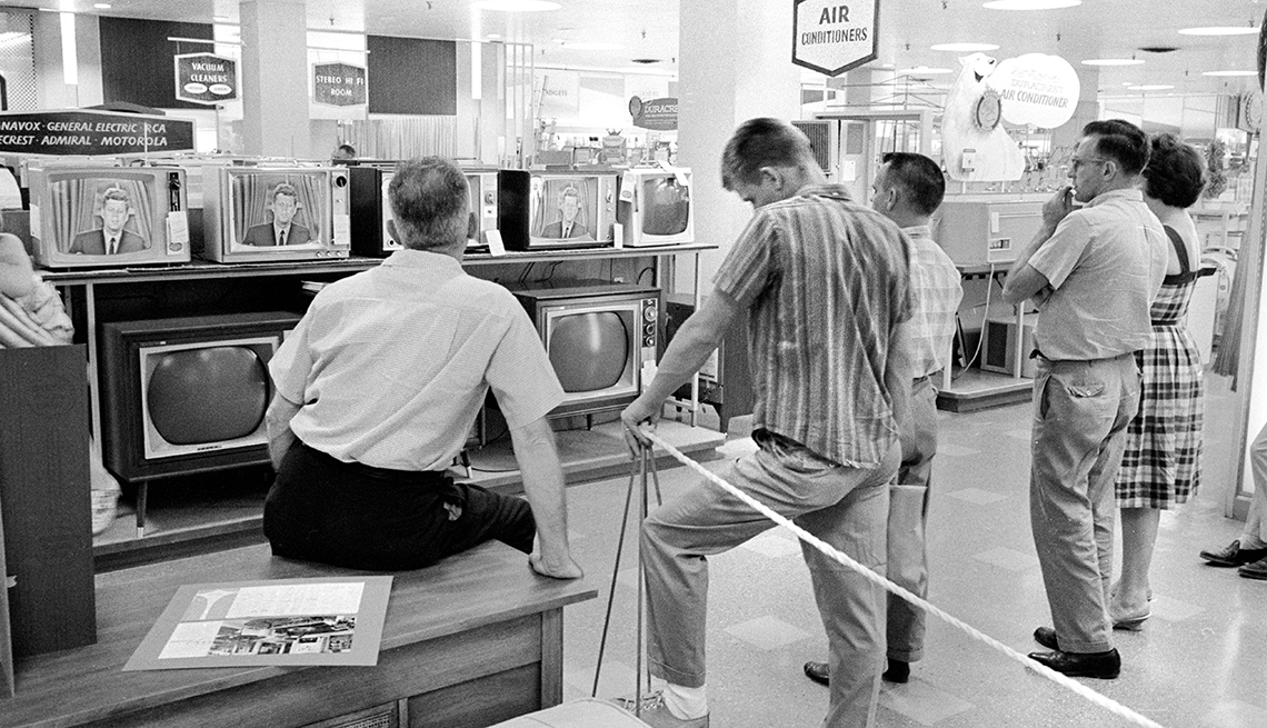 group of customers in a hechts store gather around a television to watch president john f kennedy in this nineteen sixty two photo