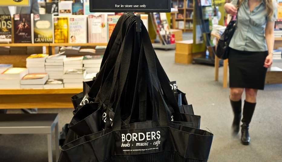 scene of a shopper walking in a bookstore with a rack of shopping bags in the foreground