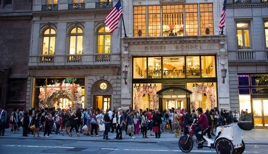 evening street view of the front of a henri bendel retail store with shoppers lined up outside from two thousand eleven