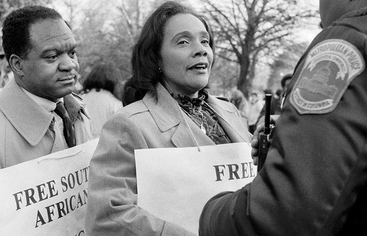 Coretta Scott King and delegate Walter Fauntroy of Washington, D.C. talk to a D.C. police officer while protesting outside the South African embassy in 1984.