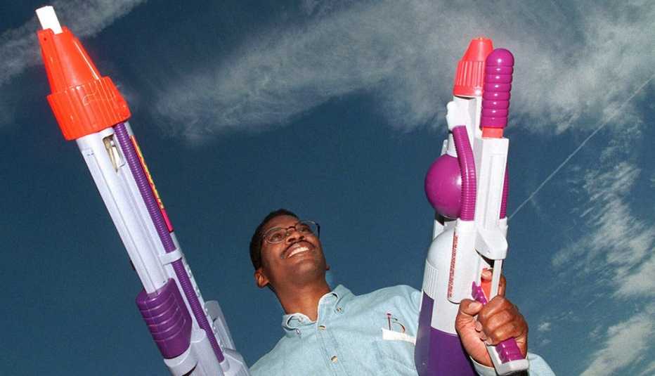 Lonnie Johnson poses with two Super Soaker water guns