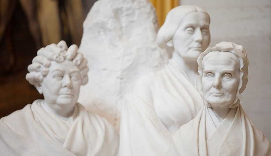 A white statue showing three women suffragist