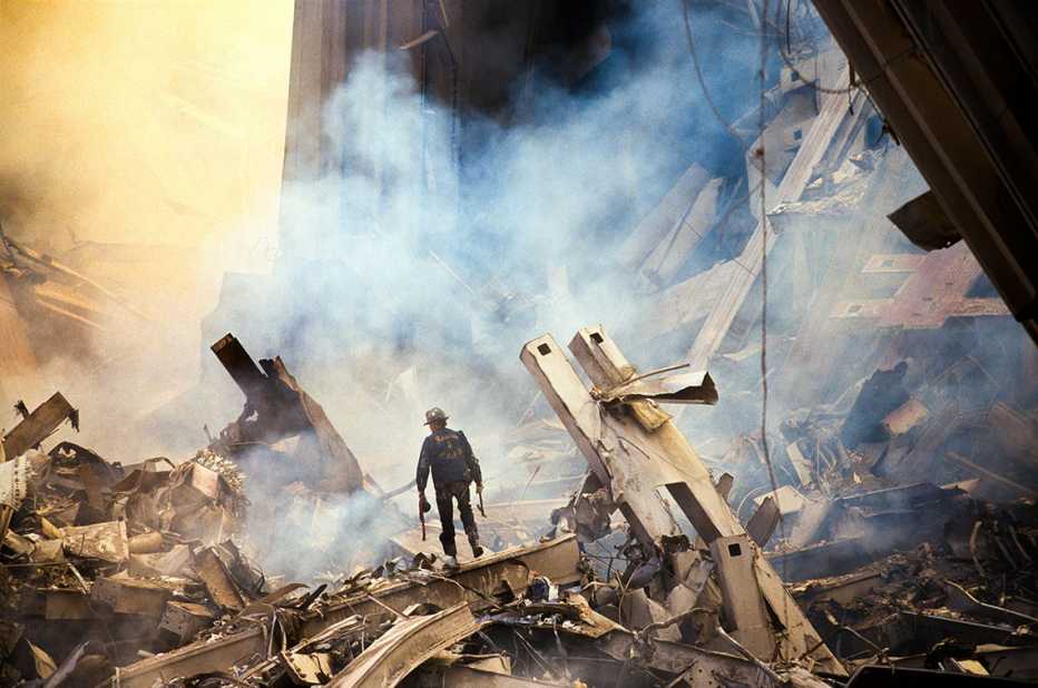 a lone first responder is dwarfed by the rubble of the world trade center after the september eleventh attack