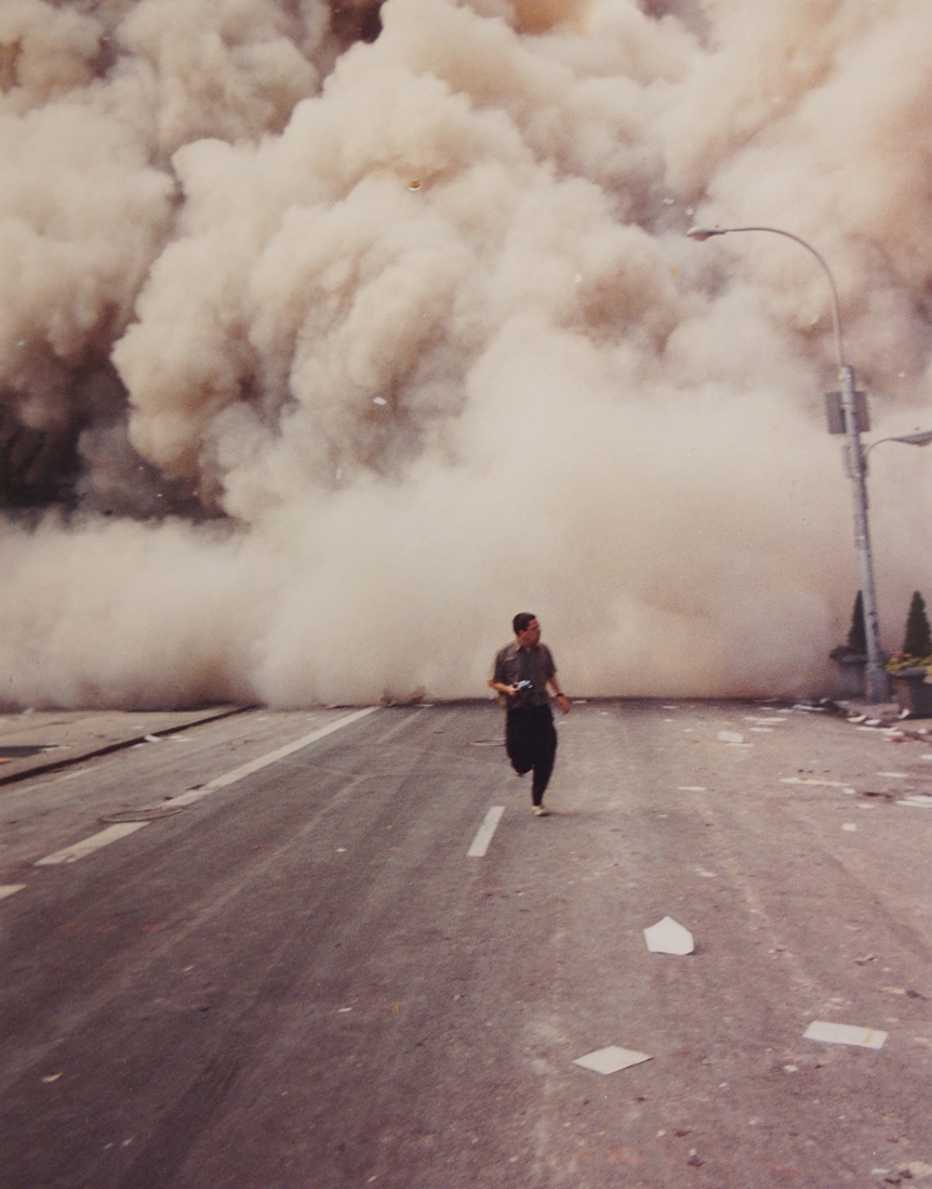 editor george mannes runs from the twin towers in new york city on september eleventh surrounded by a huge dust cloud