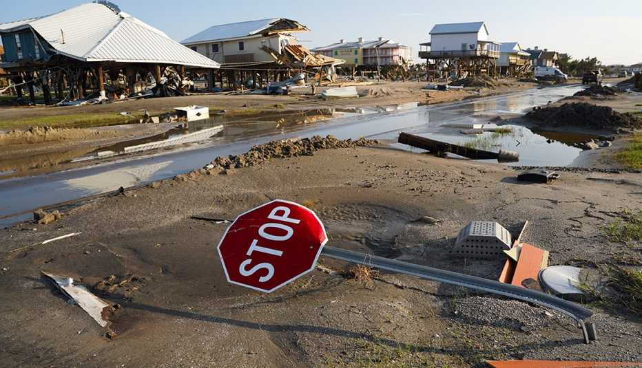 a bent over stop sign and destroyed homes after hurricane ida