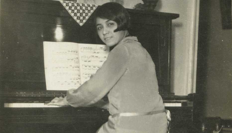 Clotilde Arias sitting at the piano in her Brooklyn, New York apartment