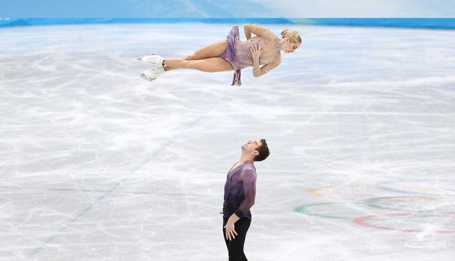 Team USA figure skater Brandon Frazier looks up while partner Alexa Kneirim spins in the air on the ice
