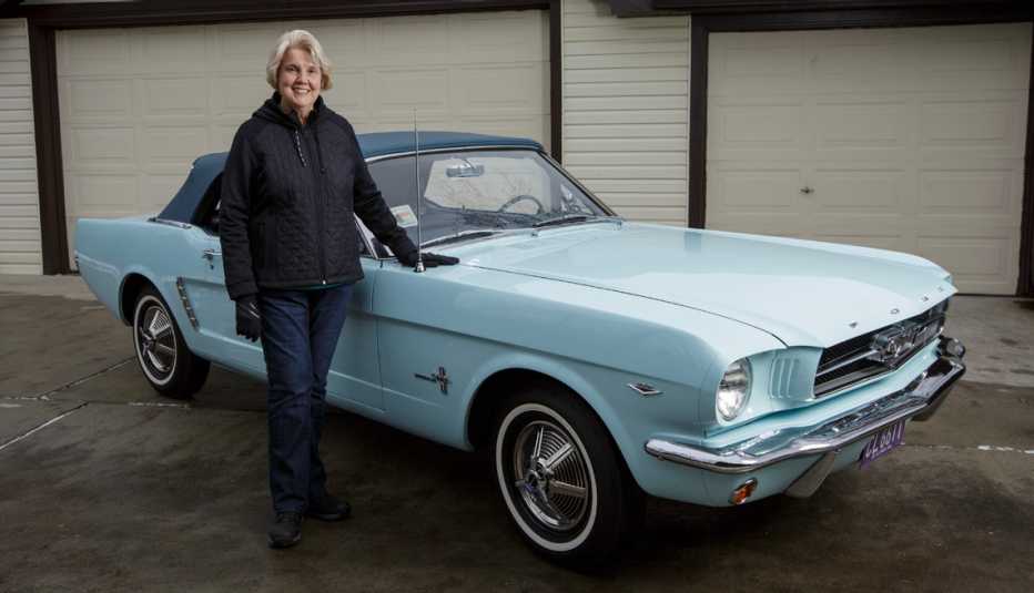 gail wise standing with her ford mustang the first of its kind sold in america