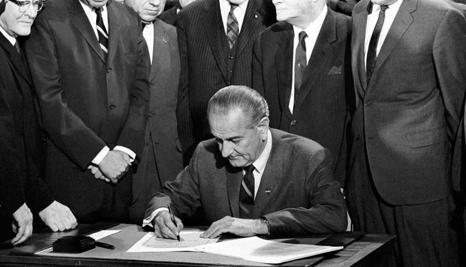 Men watch as President Lyndon B. Johnson signs the Bilingual Education Act in 1968.