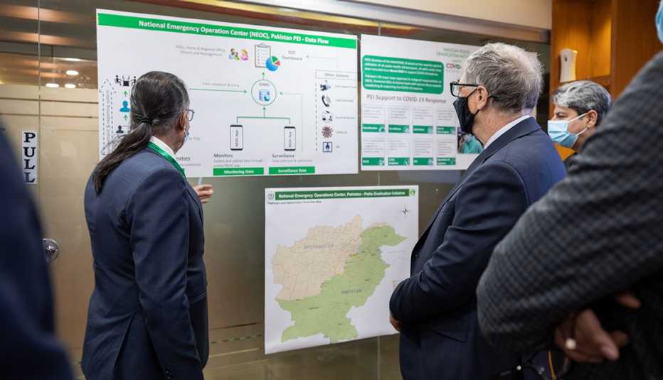 Dr. Shahzad Baig and Bill Gates look at polio vaccination and COVID-19 response maps and data during his visit of the control room at the National Emergency Operation Center (NEOC) in Islamabad, Pakistan, on February 17, 2022.