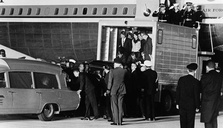 The casket of John F Kennedy is lowered from Air Force One into a waiting hearse