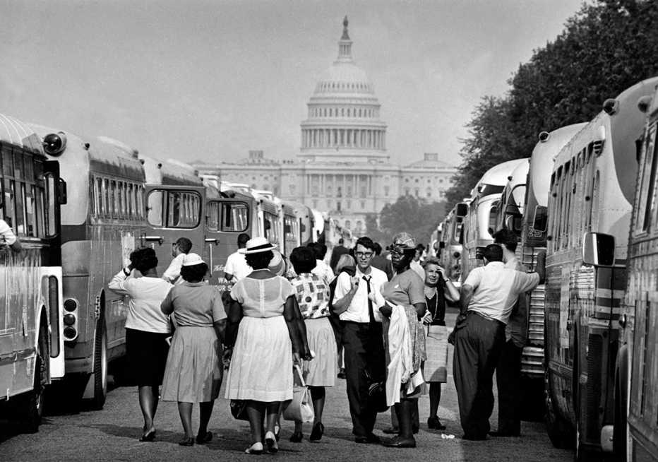 charter bus passengers walk between busses towards the u s capitol during the march on washington